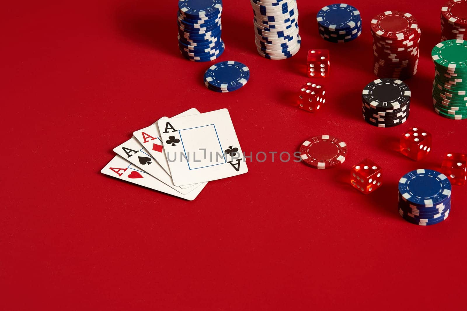 Casino gambling poker equipment and entertainment concept - close up of playing cards and chips at red background. Four of a Kind. Casino background. Copy space. Still life