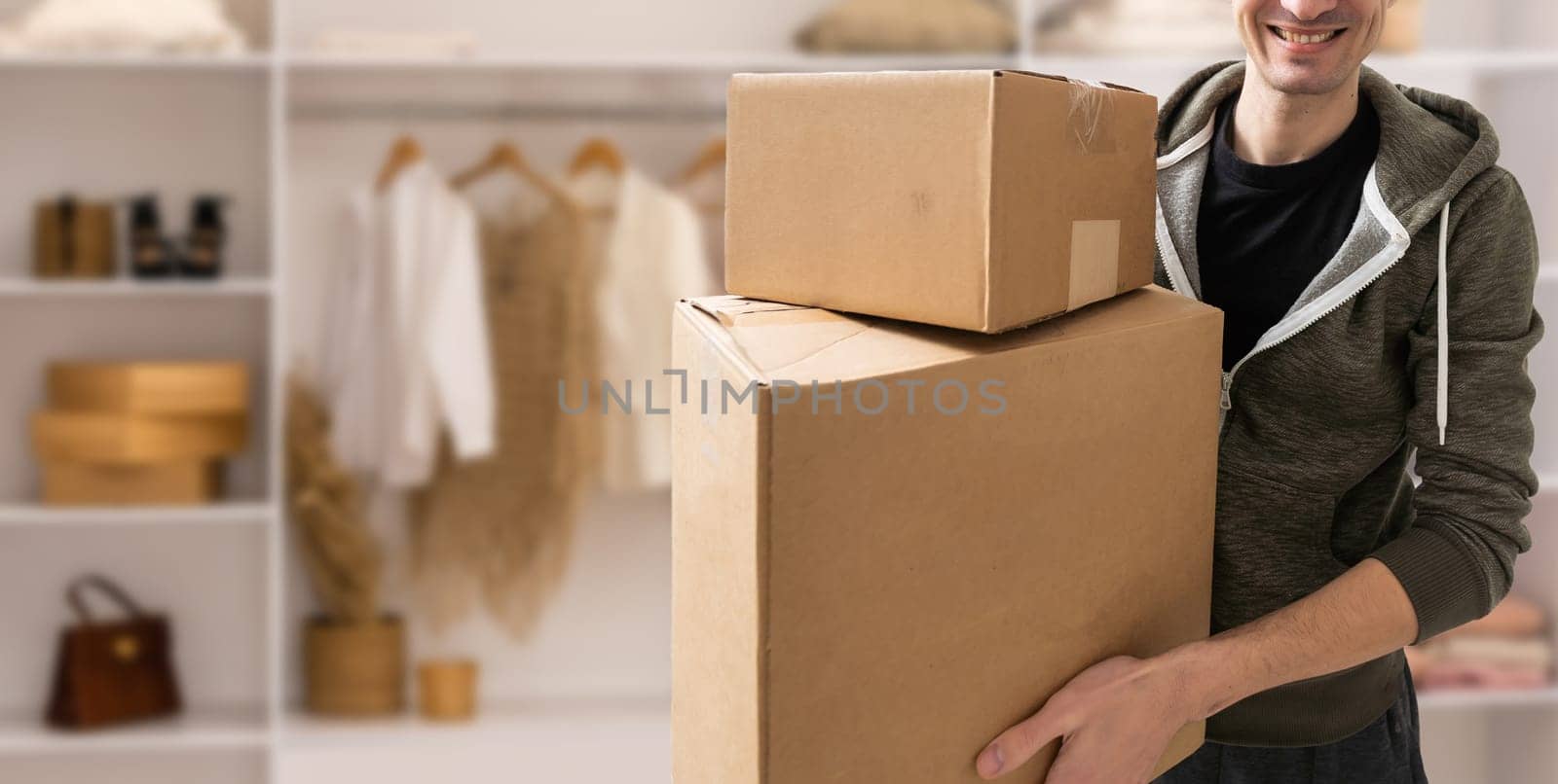 young man carries moving boxes.