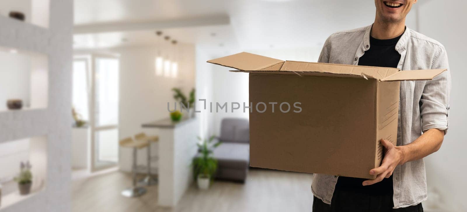 young delivery man standing with parcel post box.