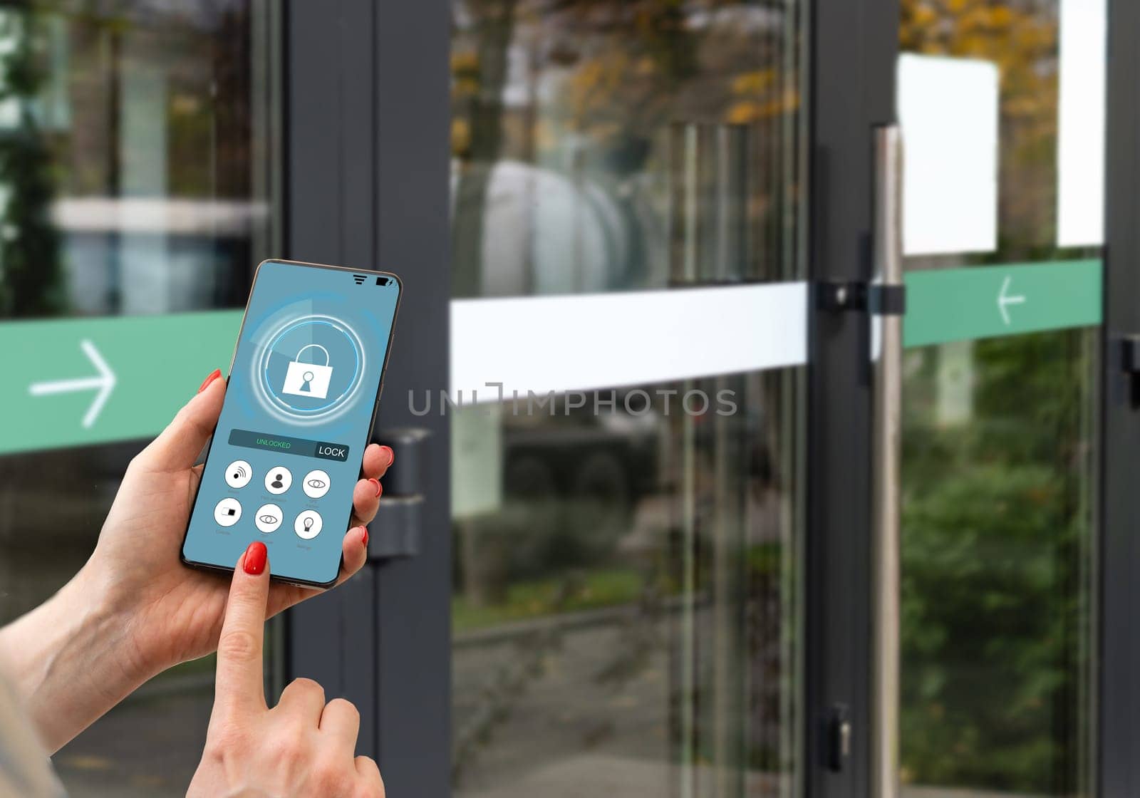 Cropped image of female entering secret key code for getting access and passing building using application on mobile phone, woman pressing buttons on control panel for disarming smart home system.