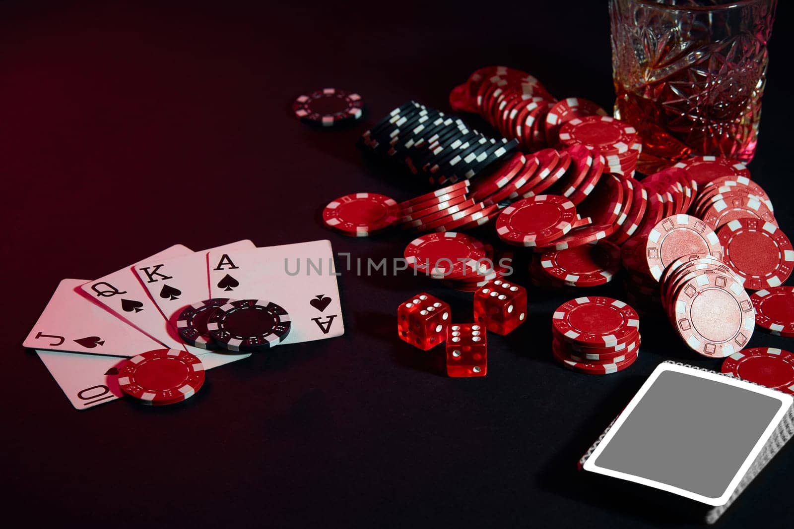 Cards of poker player. On the table are chips and a glass of cocktail with whiskey. Still life. The concept of gambling. Poker Online. Combination of cards - Royal Flush