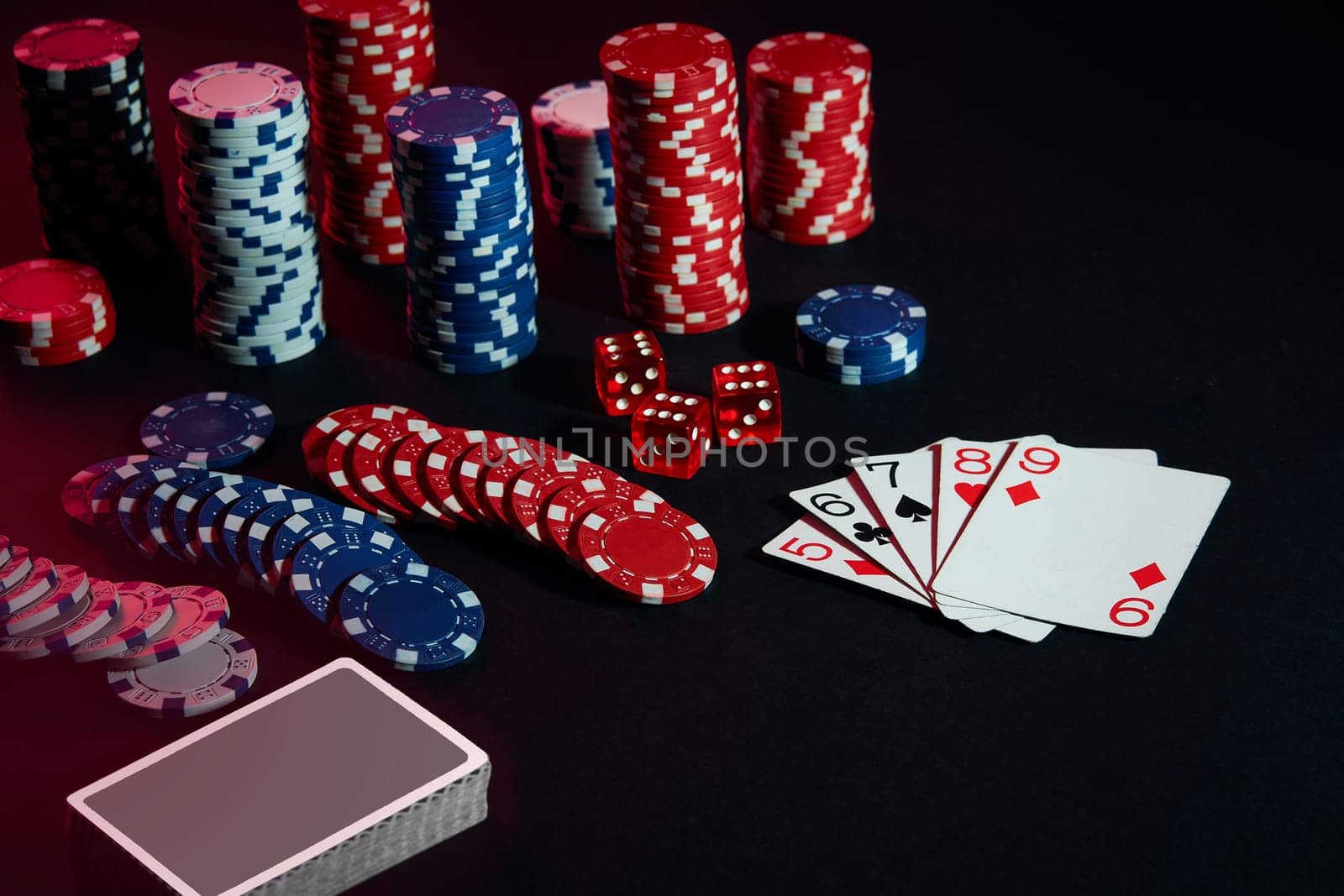 Casino chips and cards on black table surface. Gambling, fortune, game and entertainment concept - close up. Poker Online. Copy space. Ideal for advertisement. Still life