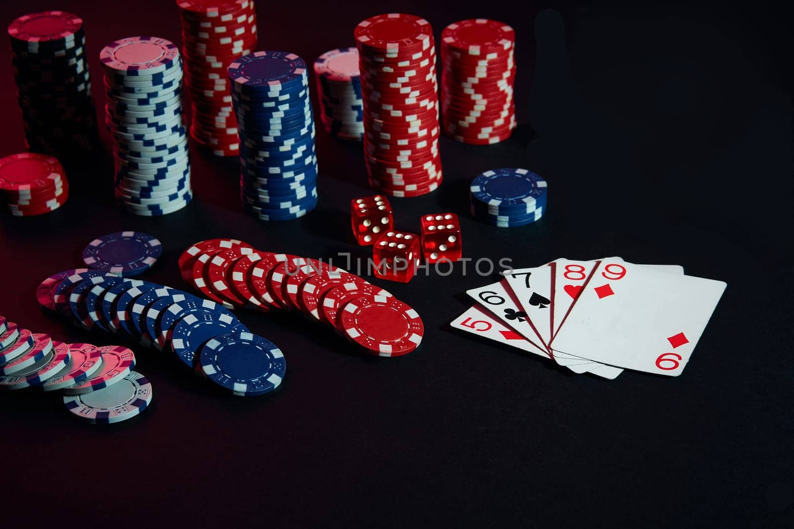Casino chips and cards on black table surface. Gambling, fortune, game and entertainment concept - close up. Poker Online. Copy space. Ideal for advertisement. Still life