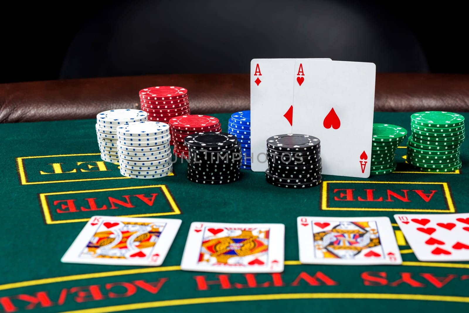 Poker play. Chips and cards on the green table