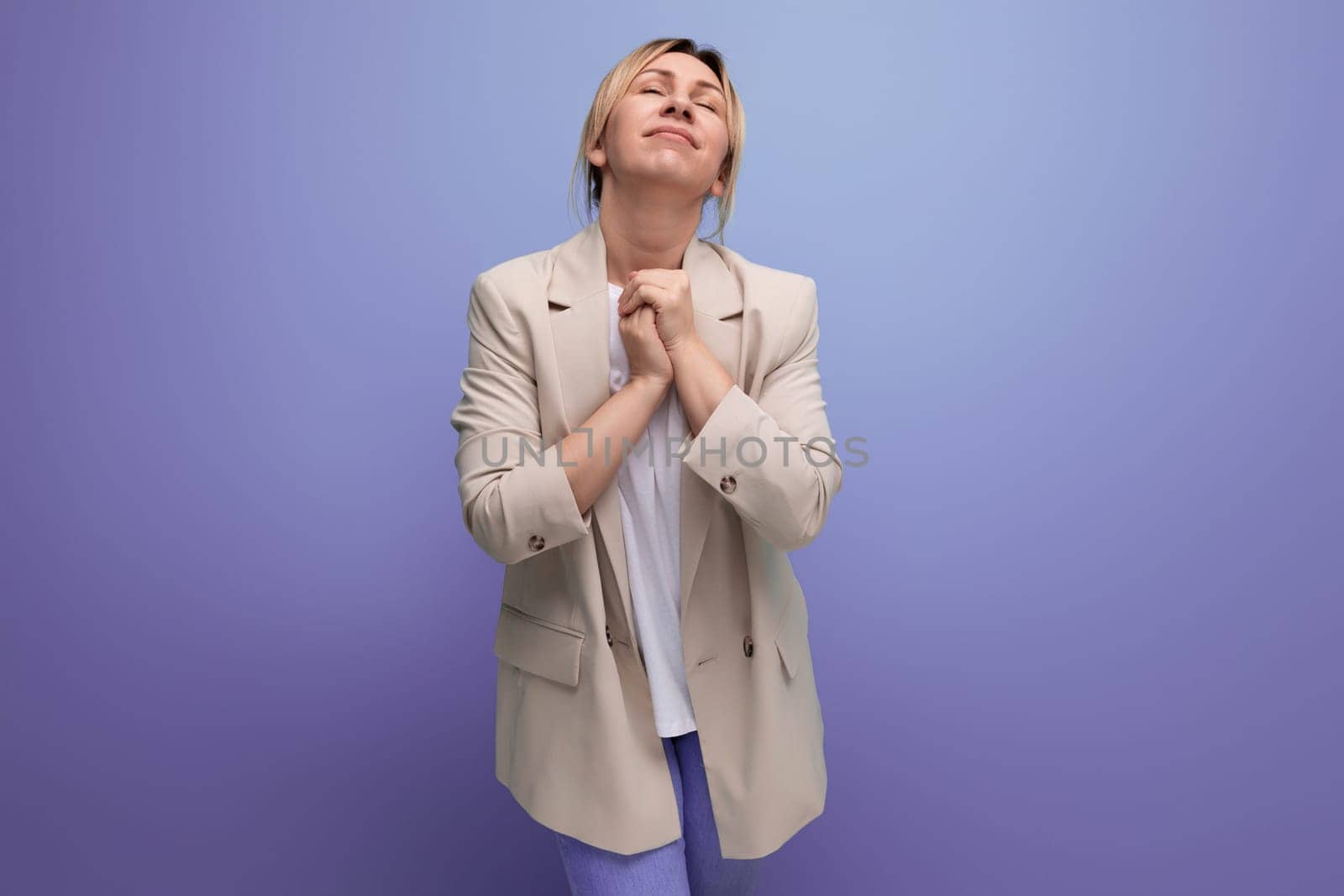 portrait of a kind pleasant young blonde business woman in a jacket on the background with copy space.