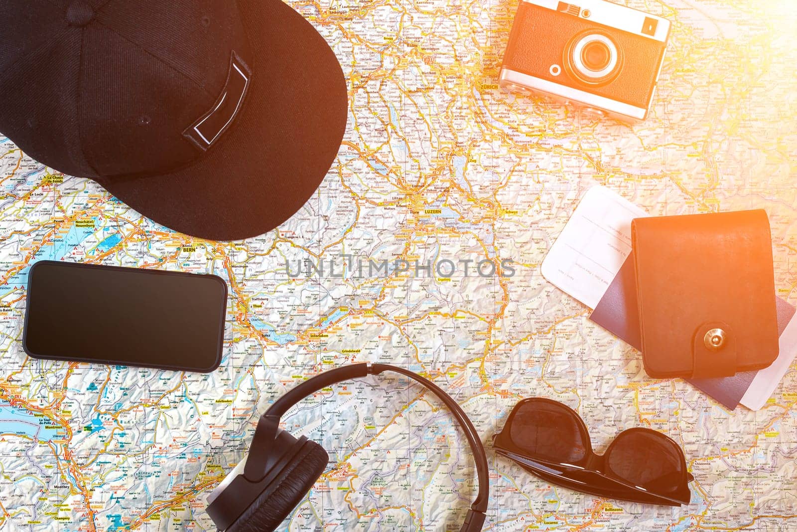 Accessories for travel. Passport, photo camera, smart phone and travel map. Top view. Holidays and tourism concept. Copy space. Still life. Flat lay. Sun flare