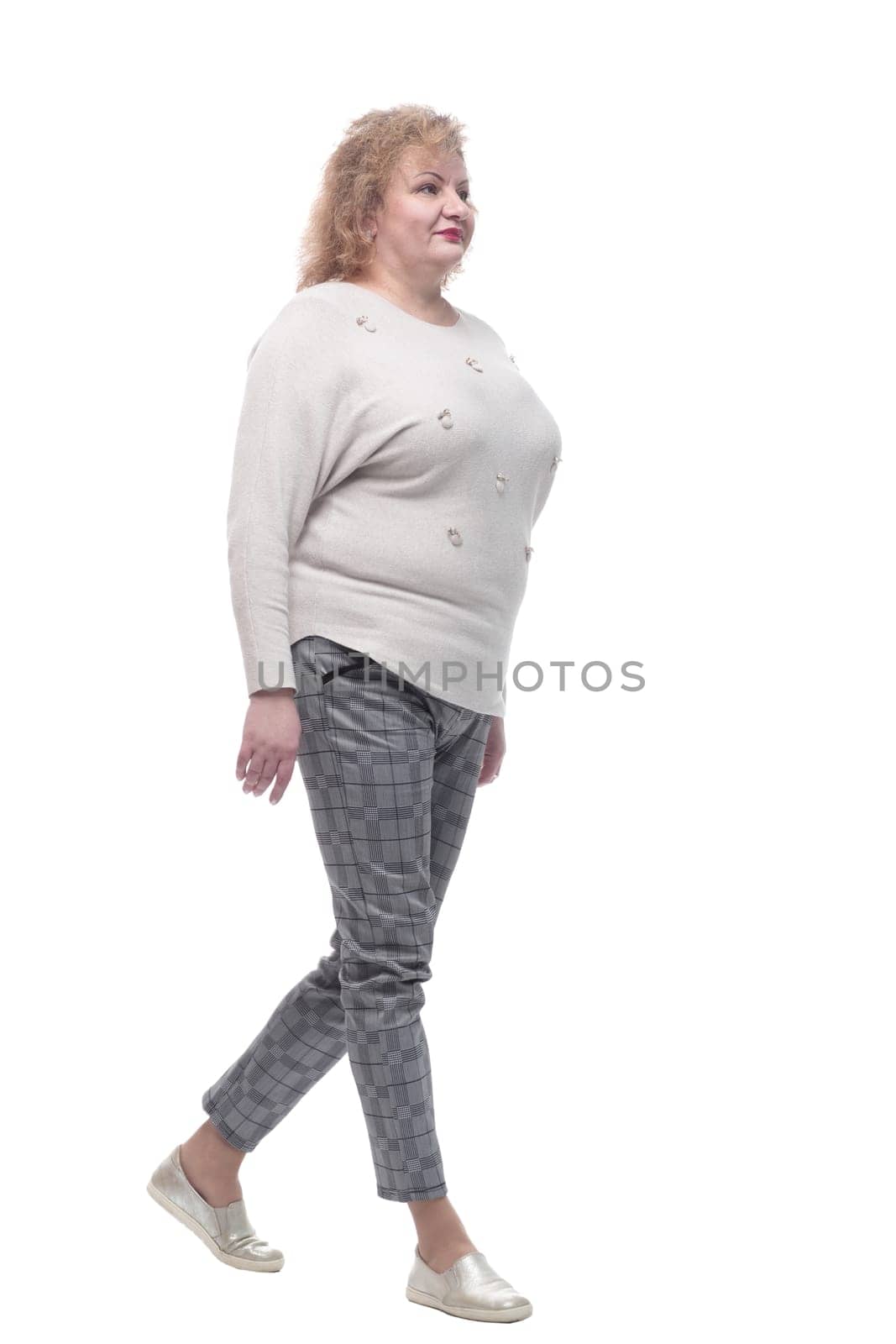 casual woman in a jumper and trousers striding forward. isolated on a white background.