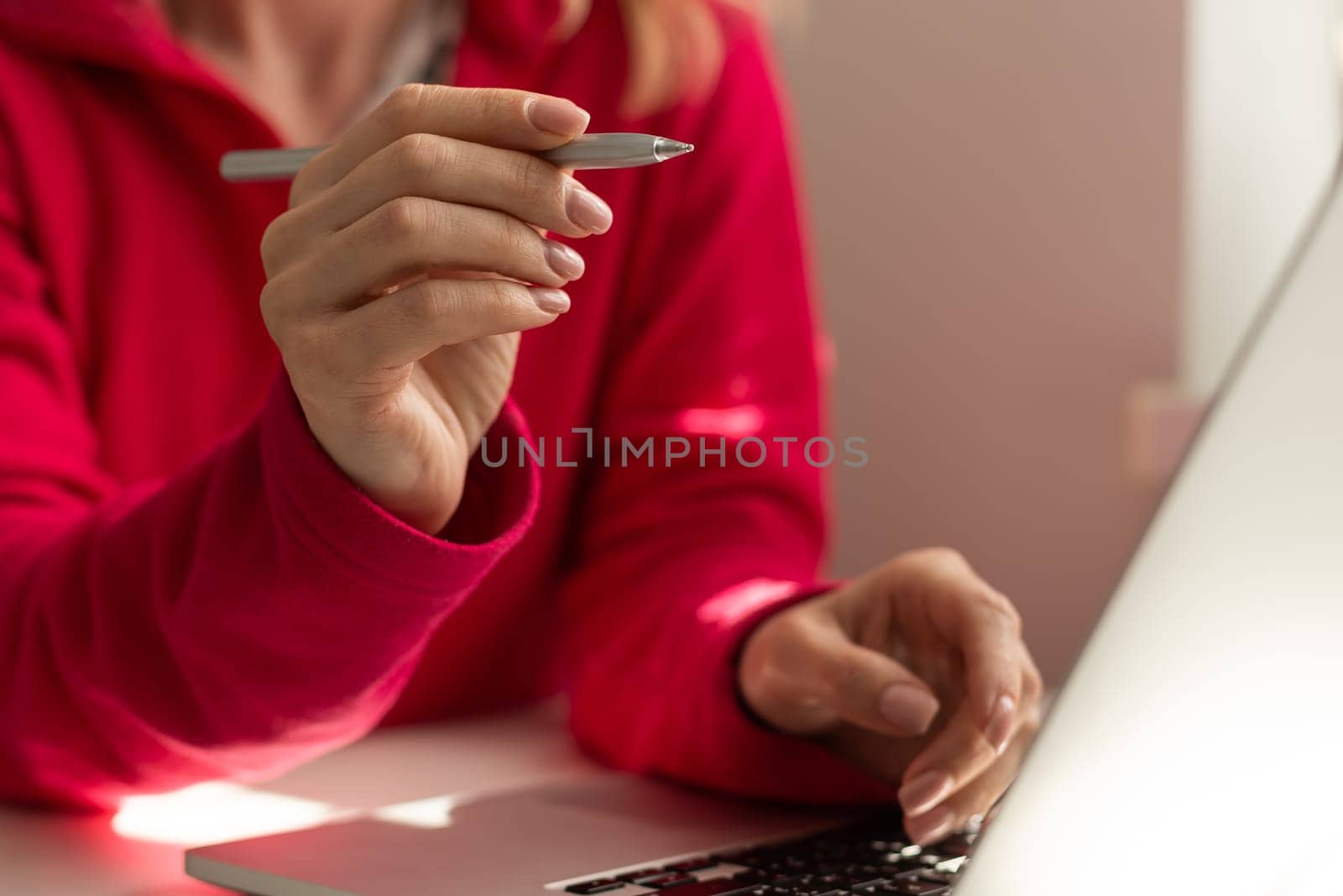 Hand of freelancer pointing on laptop screen with pen at desk