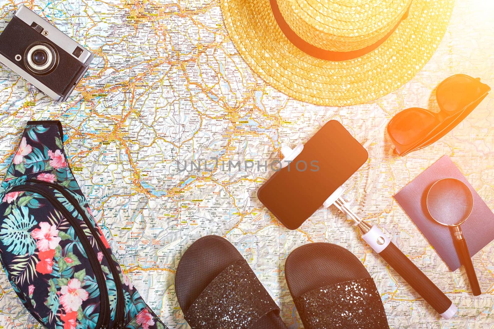Accessories for travel. Passport, hat, smart phone and travel map. Top view. Holidays and tourism concept. Copy space. Still life. Flat lay. Sun flare