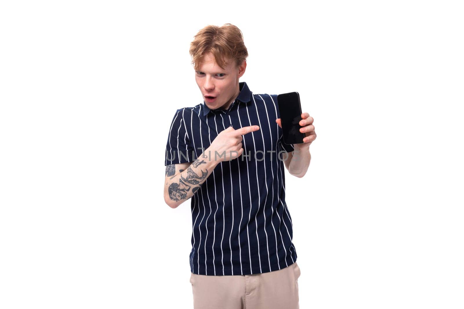 handsome young white-haired man in a blue polo with tattoos shows ads on the phone by TRMK