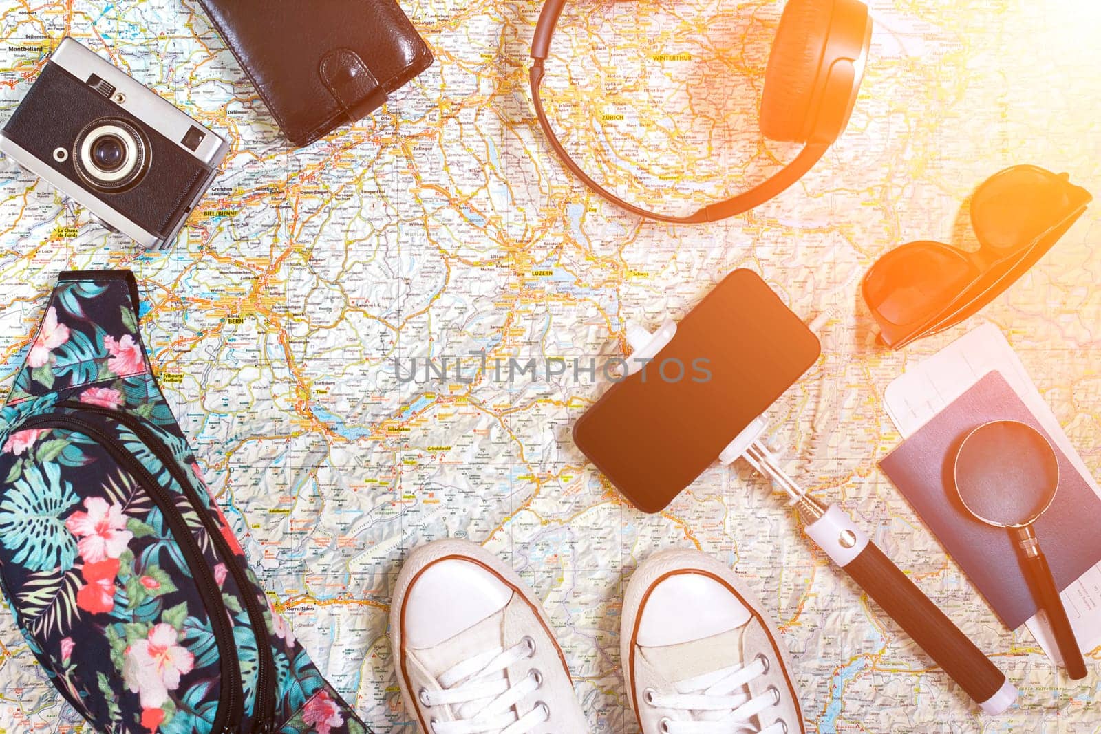 Accessories for travel. Passport, hat, smart phone and travel map. Top view. Holidays and tourism concept. Copy space. Still life. Flat lay. Sun flare