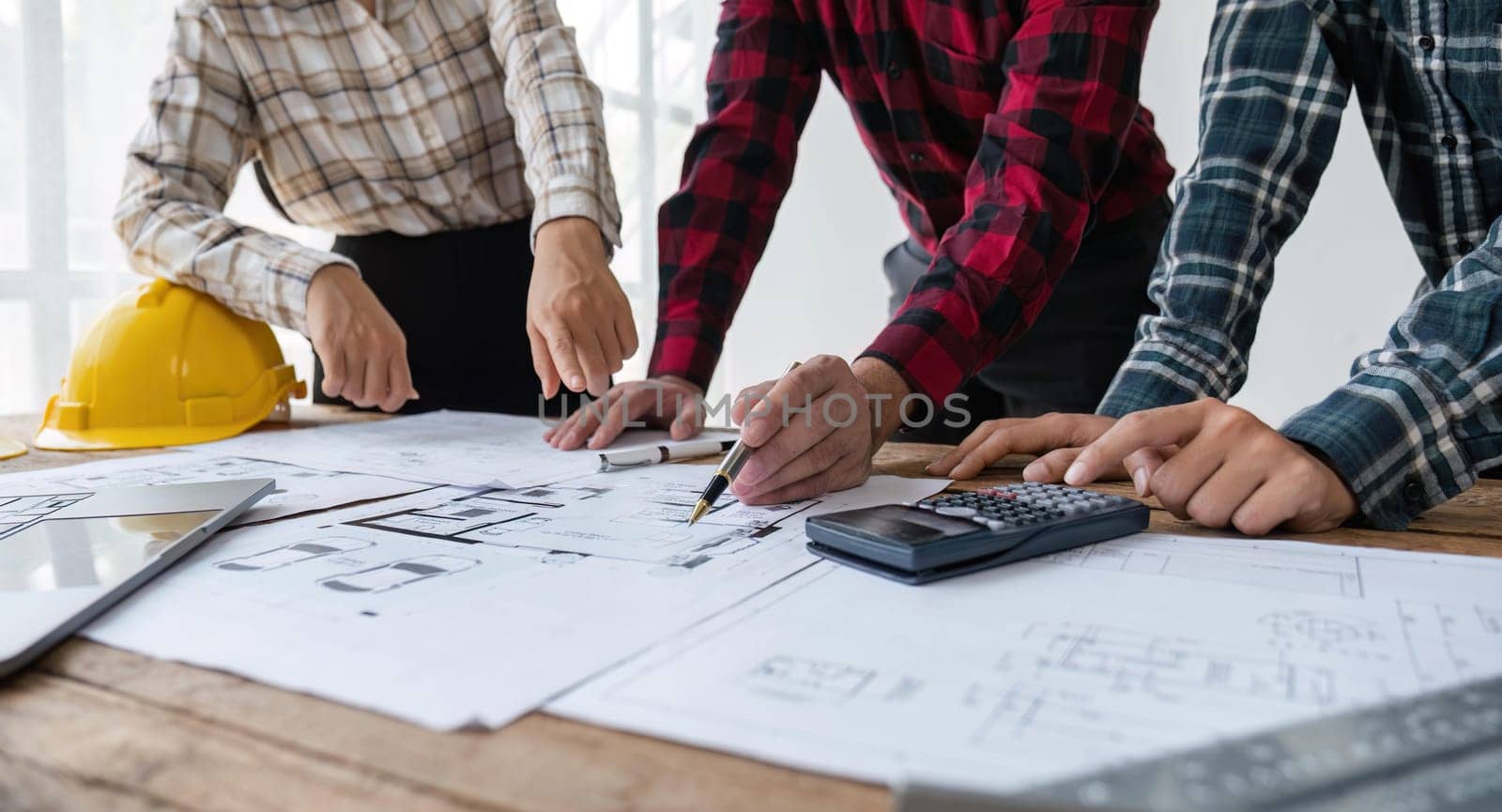 engineer people meeting working and pointing at a blueprint in office for discussing. Engineering tools and construction concept.