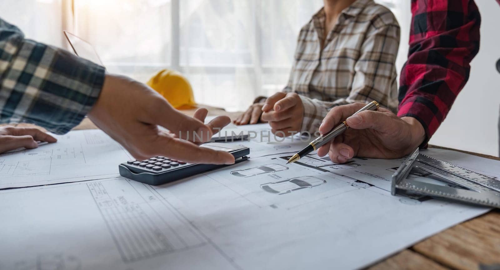 engineer people meeting working and pointing at a blueprint in office for discussing. Engineering tools and construction concept.