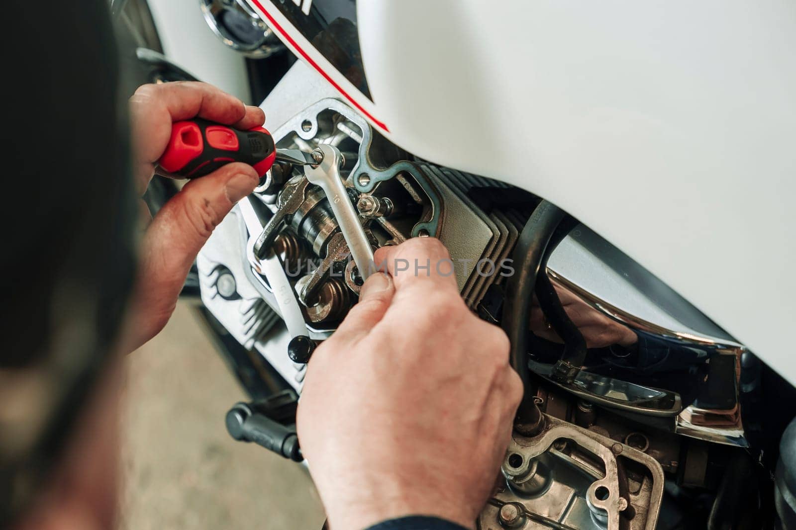 adjustment of gaps of valves in the motorcycle engine. Mechanism settings. Springs and adjusting screw of gaps of valves, dipstick. garage service or at the workshop. adjusting engine valves of motorcycle at the workshop