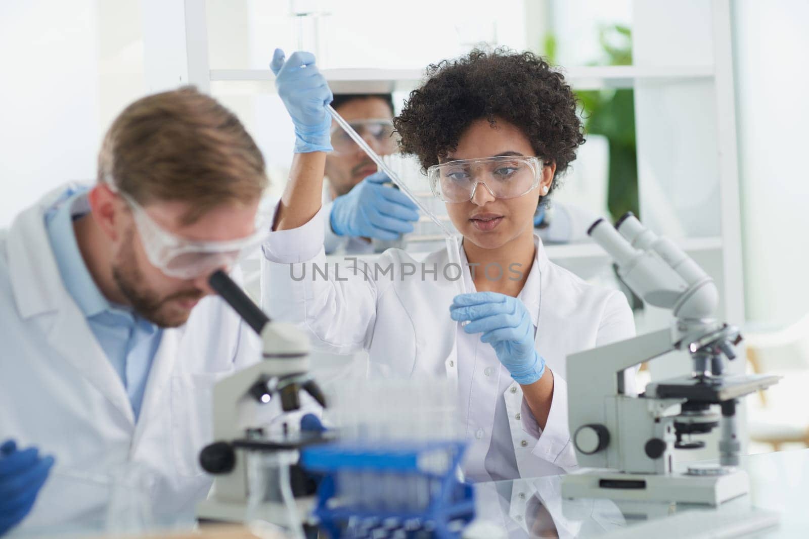 Team of Scientists Working Using Microscope, Analysing Microbiology Samples