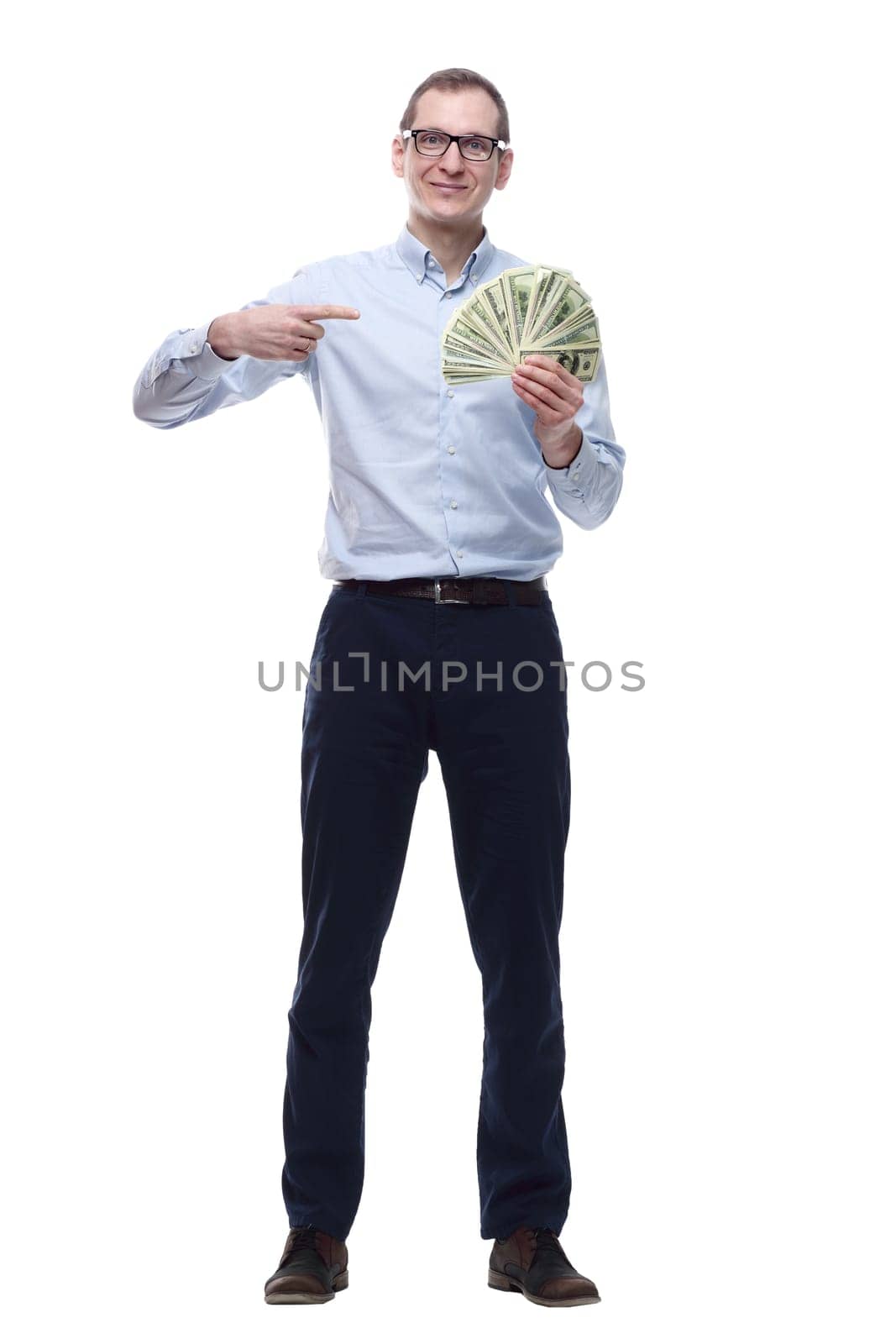 in full growth. happy man pointing to a fan of banknotes. isolated on a white background