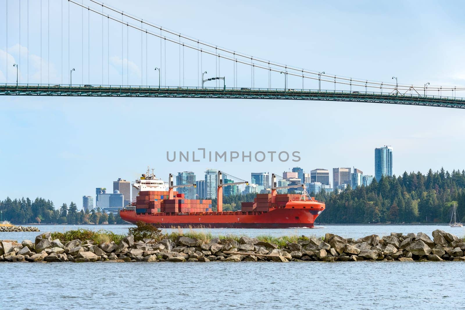 Container cargo liner in Vancouver harbor going fairway under Lions Gate bridge.