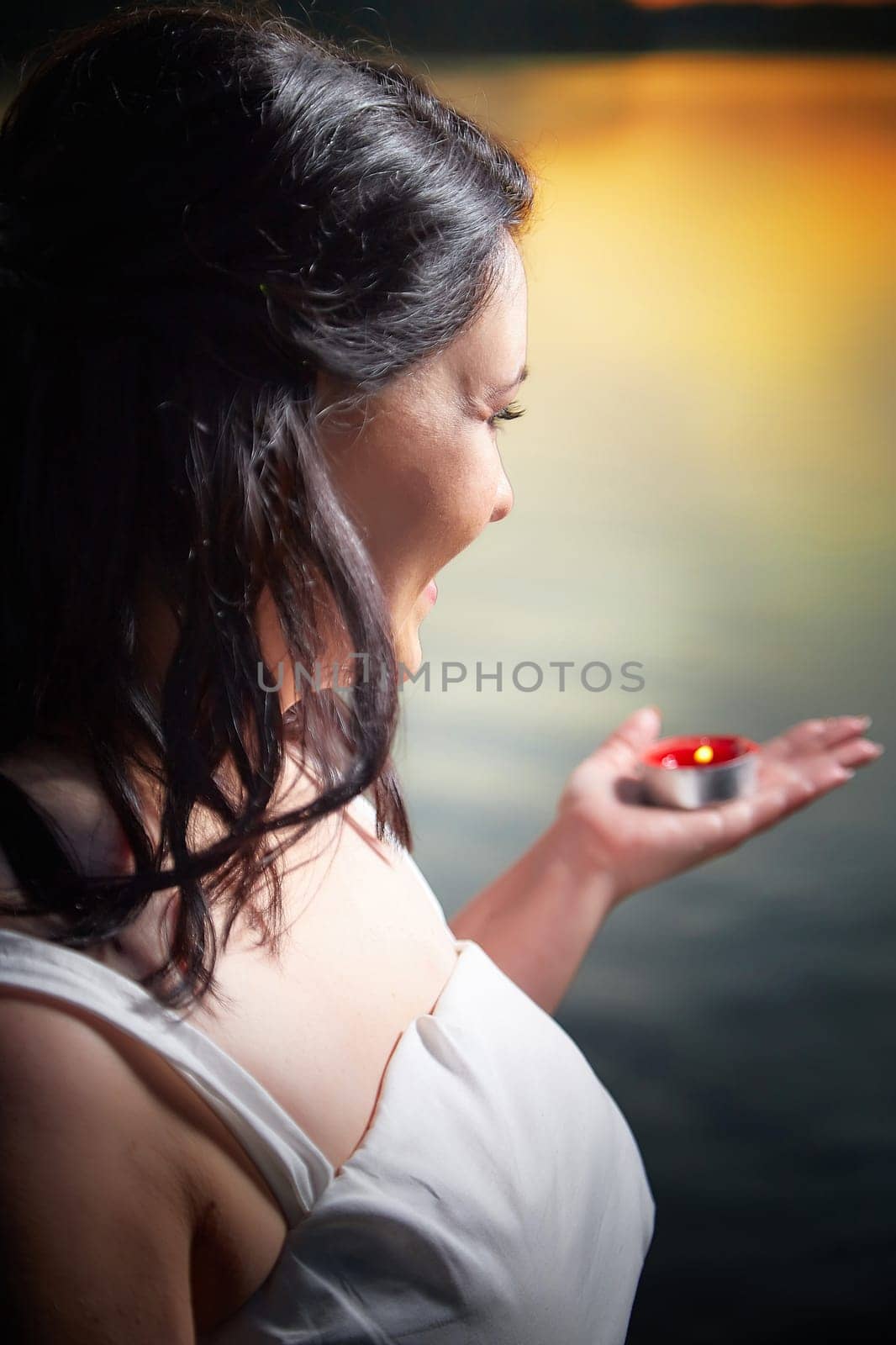 Slavic plump plump chubby girl in long white dress on the feast of Ivan Kupala with flowers and water in a river or lake on a summer evening by keleny