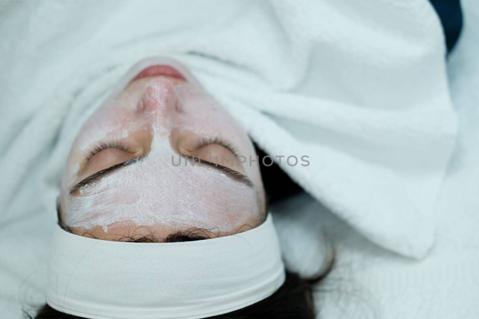 Closeup view of woman after calming cosmetic mask applied on her face by danjelaruci
