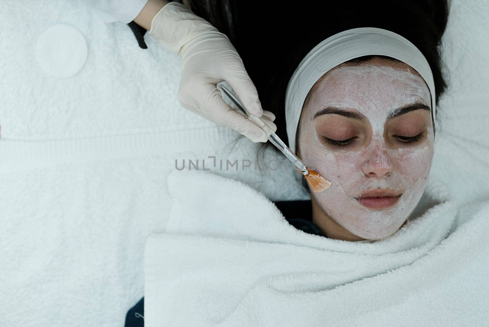 Top view of woman having a calming cosmetic mask applied on her face. post treatment mask. calming mask. post microneedling. post dermapen. Esthetician. Health and beauty.