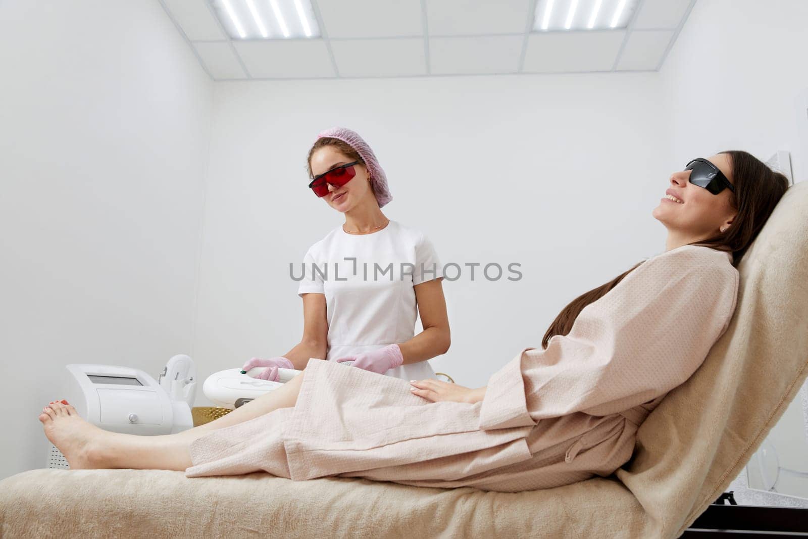 Partial view of woman receiving laser hair removal epilation on leg in a salon by Mariakray