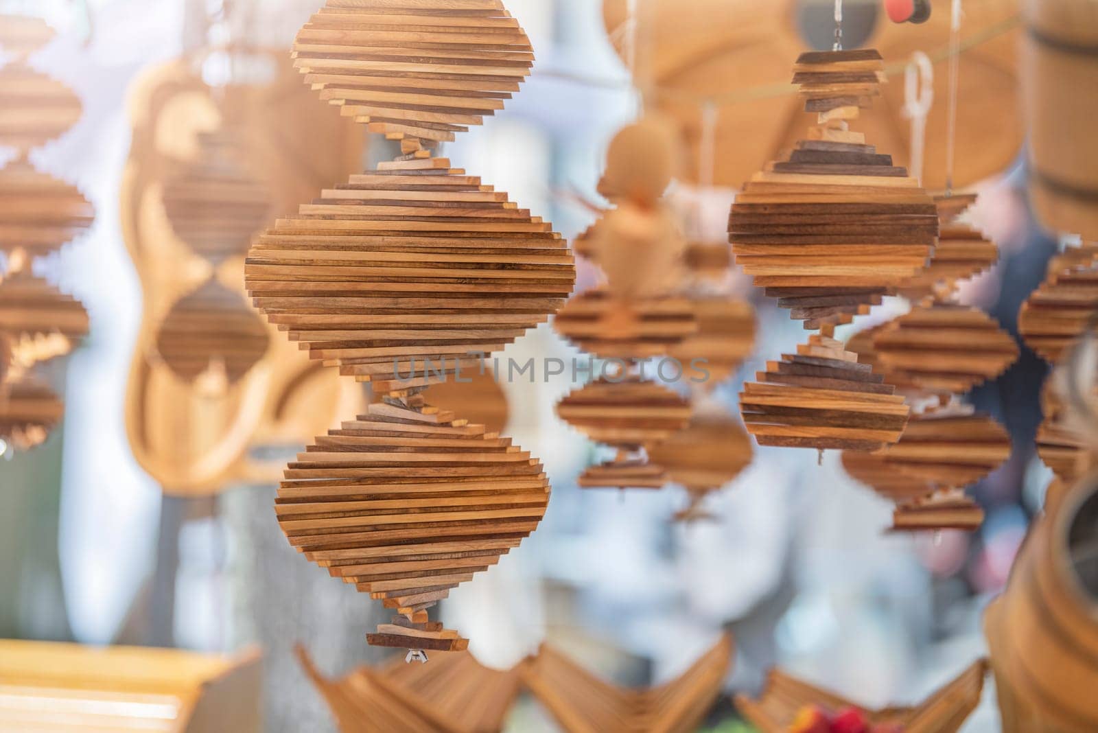 Handmade wind spinner. The wind spinner is made of strips of wood folded into a spiral, capable of spinning in the wind, designed for hanging and decoration. High quality photo