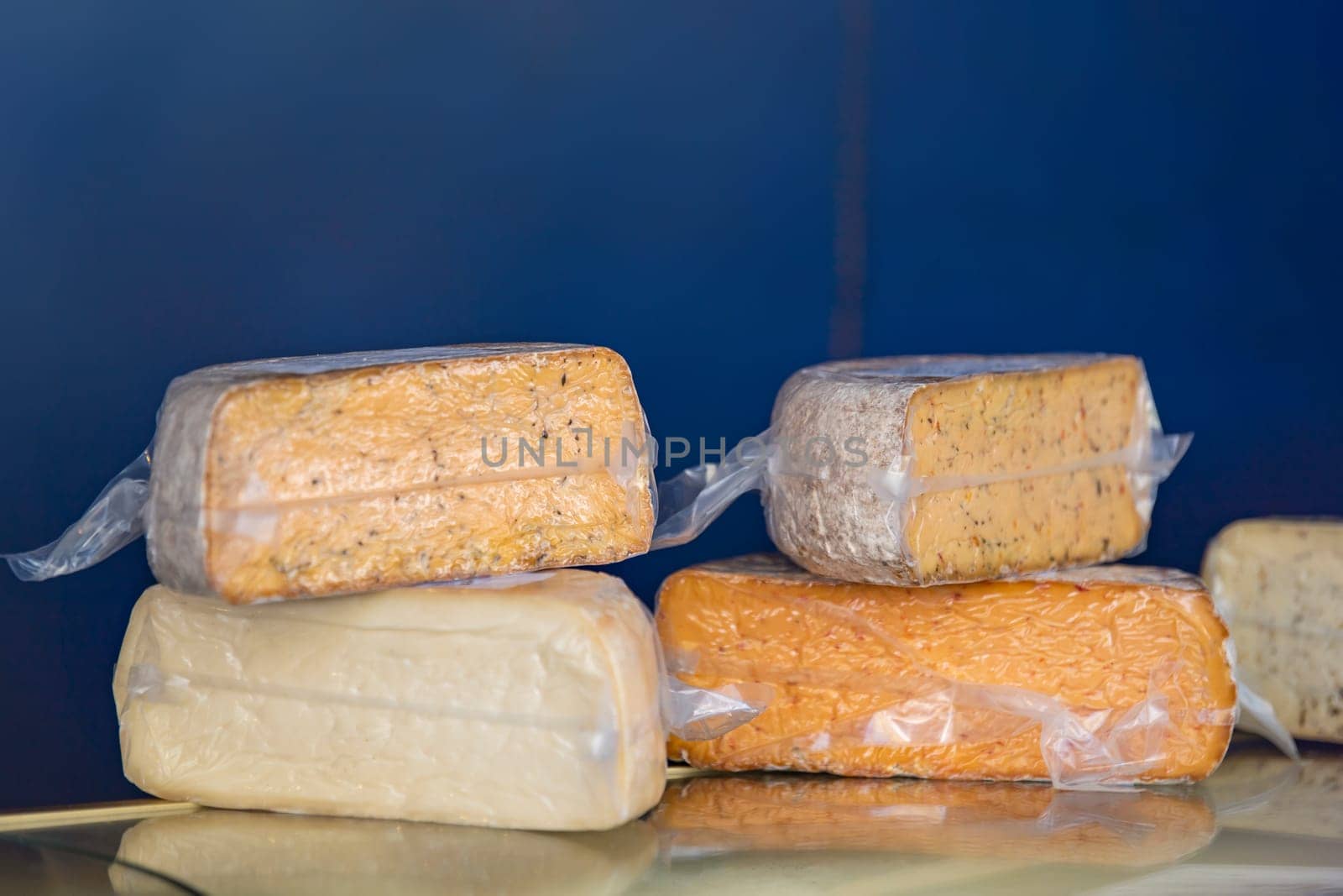 Hard cheeses. A large piece of cheese in a cheese factory, on a shelf. Production and sale of cheese. Small business concept. High quality photo