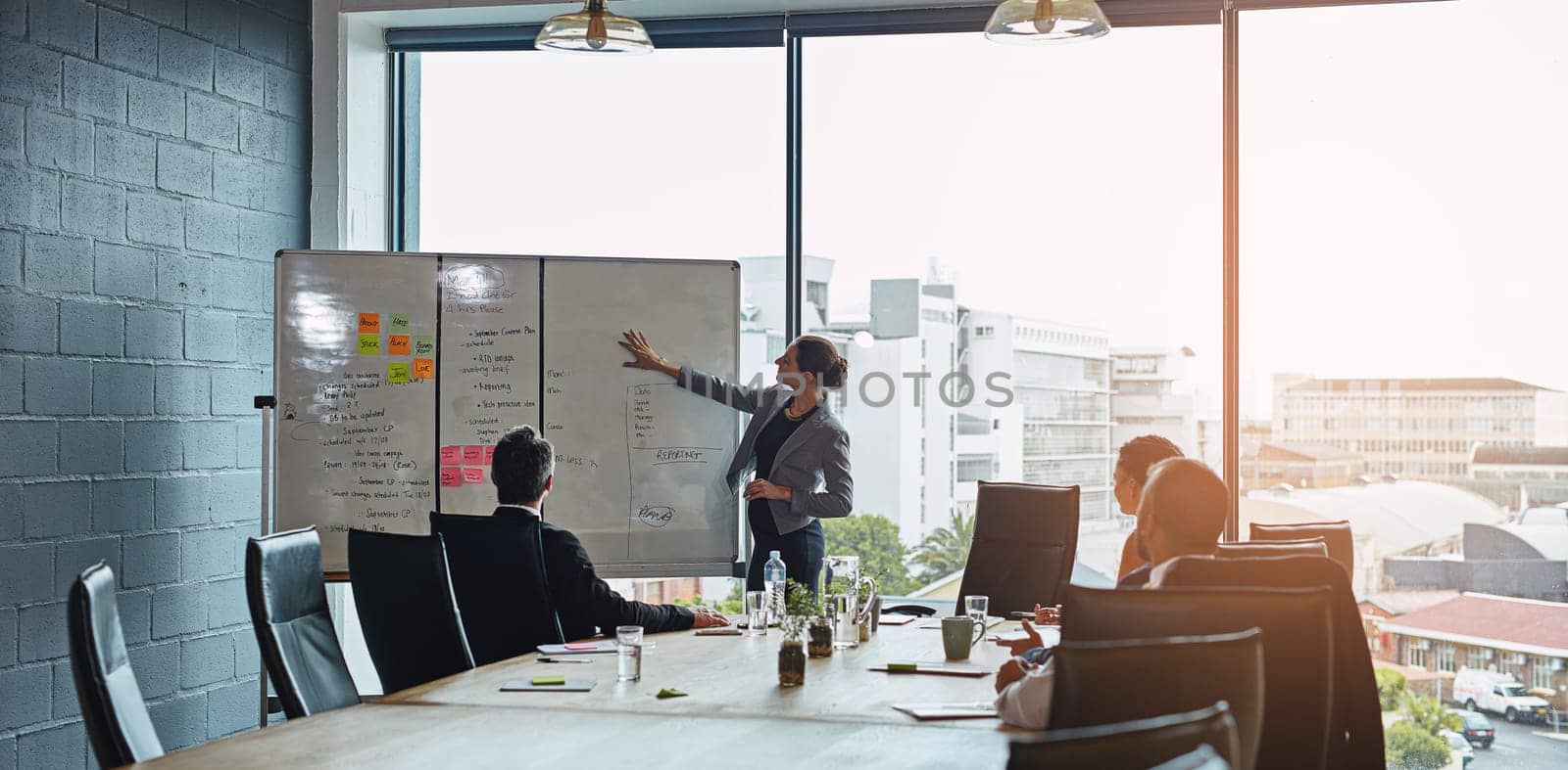 Meeting, presentation and whiteboard with a business woman in the boardroom for planning or strategy. Collaboration, flare or report in an office with people around a table during a training workshop.