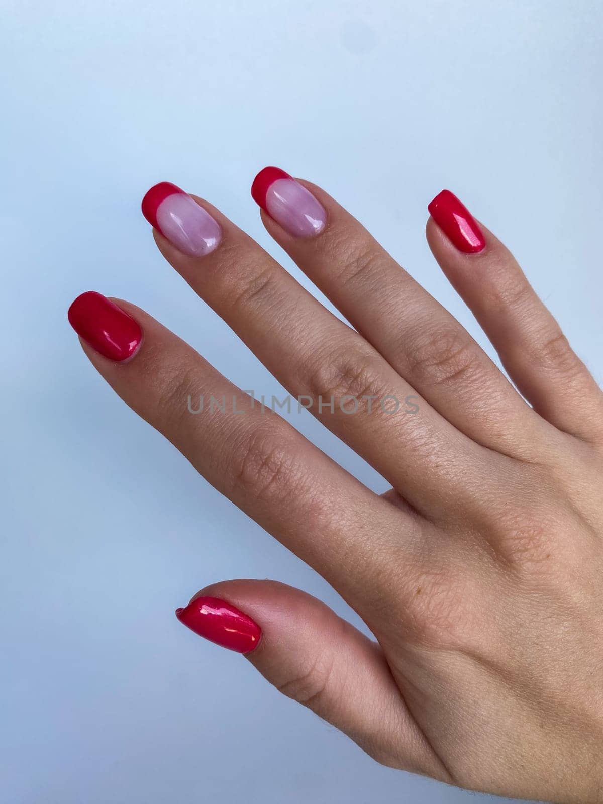 Red nail professional manicure, woman hand, beige sleeve. High quality photo