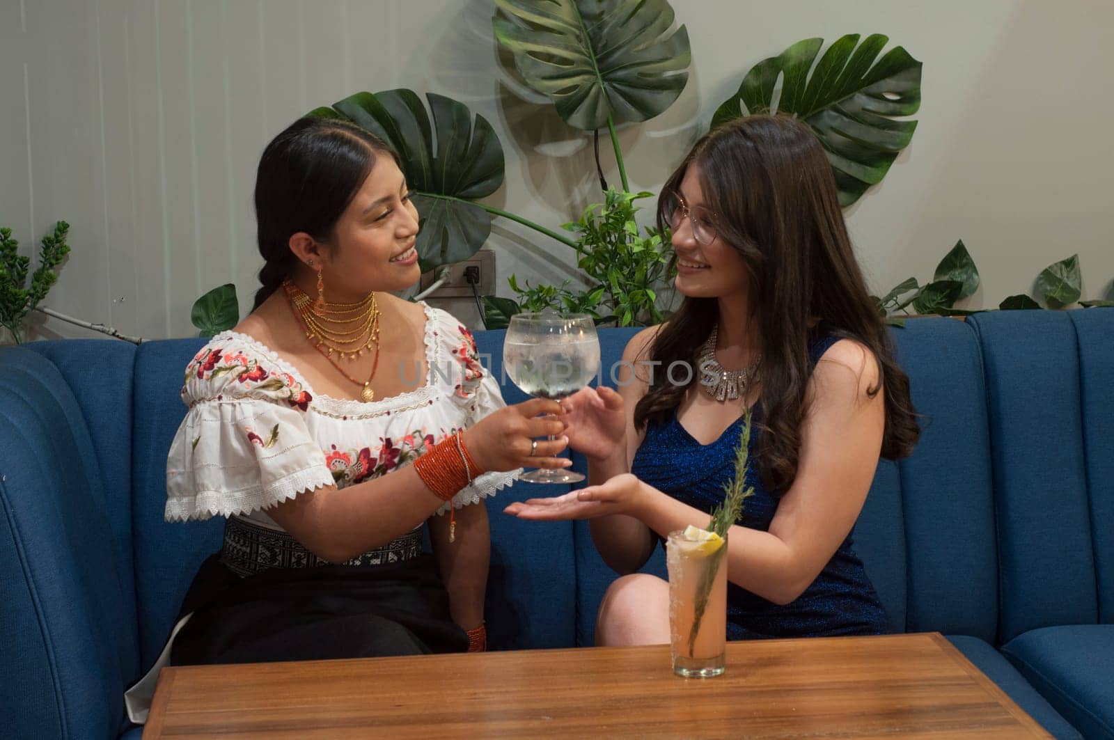 two lesbian girls in a moment of intimacy having a cocktail in a trendy restaurant. High quality photo