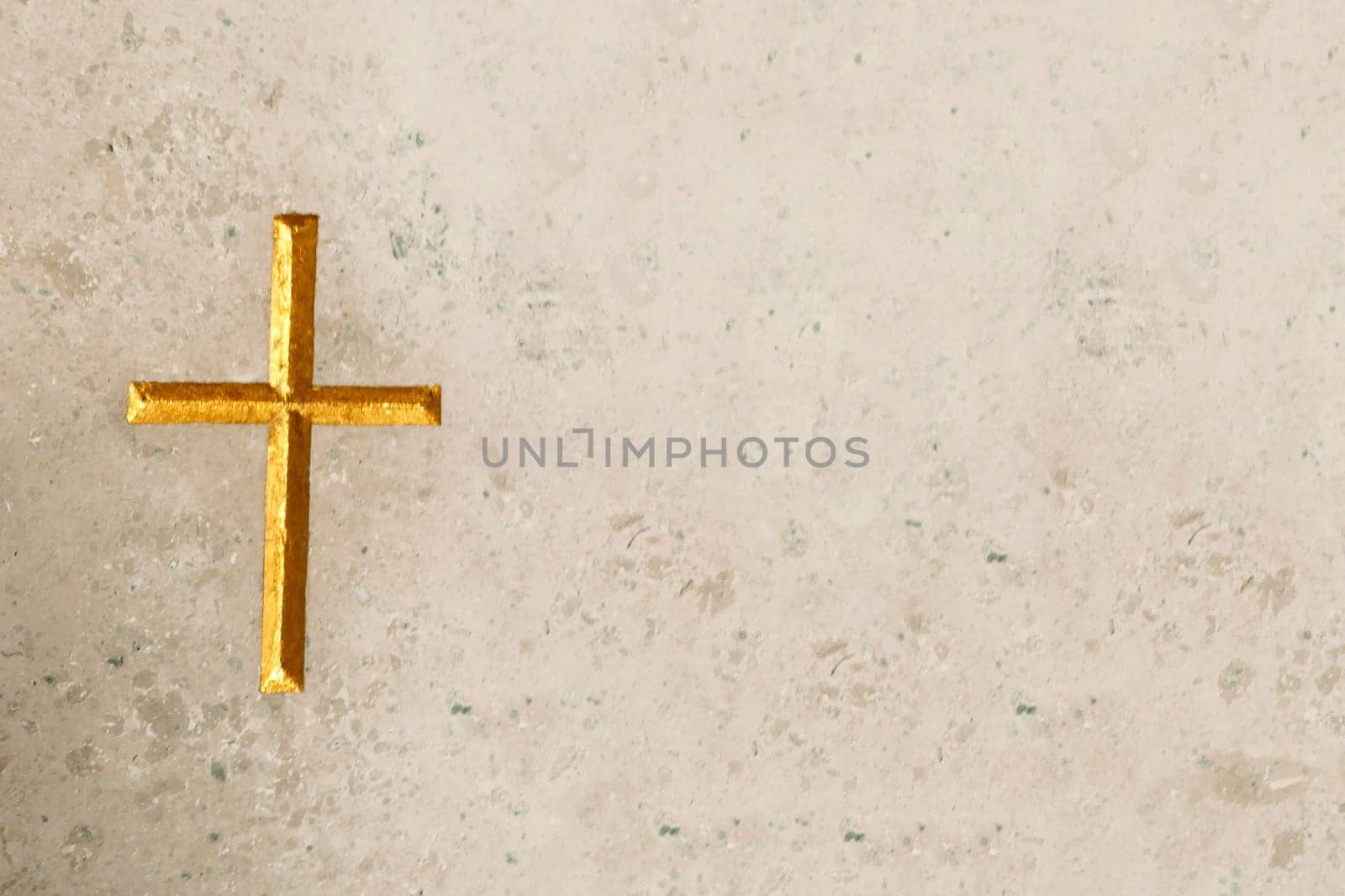 Golden cross engraved  in beige marble. With copy space. Meant as background