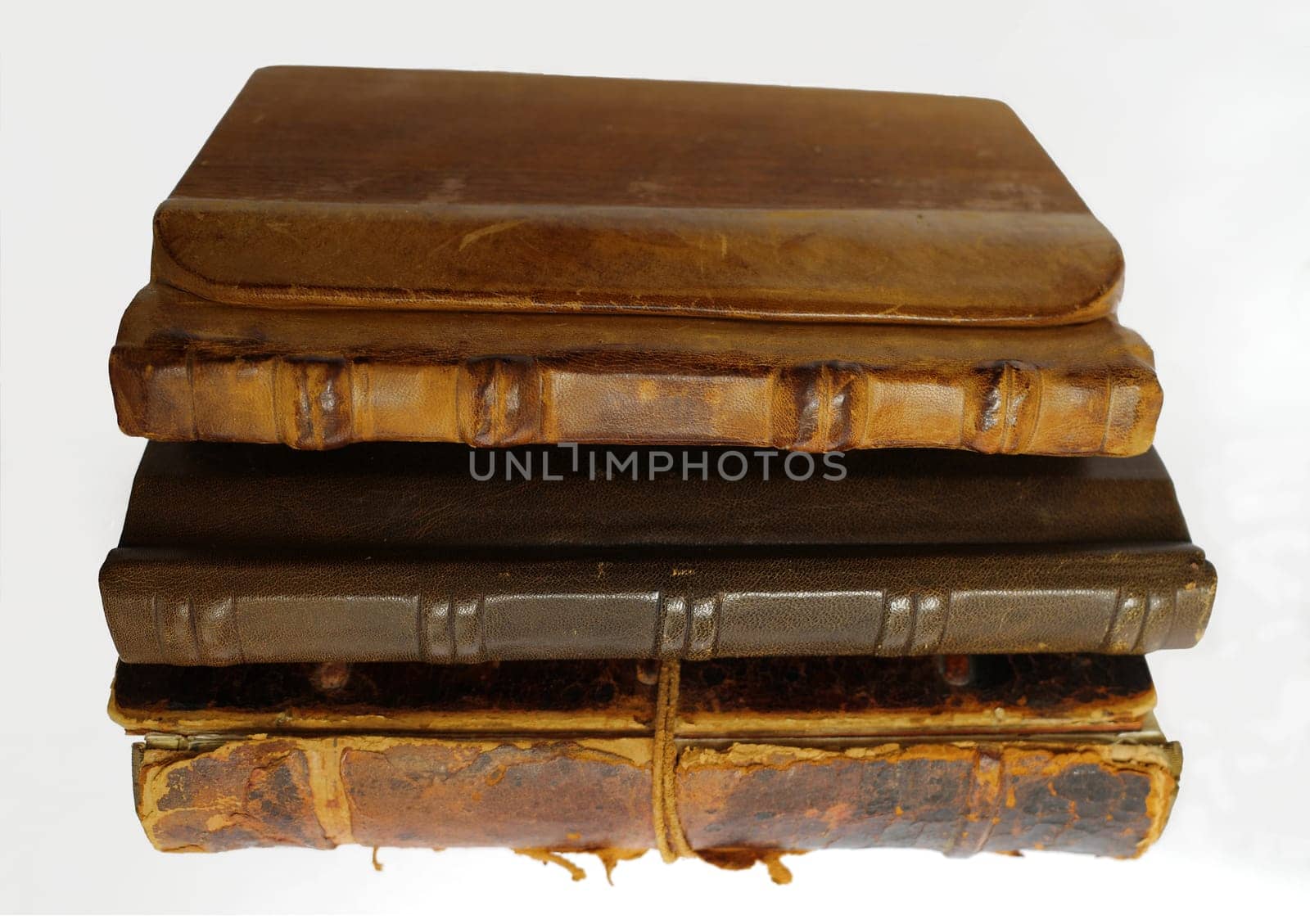 Collection of three old books on a white background. The cover of these books is made of leather or leather and wood.