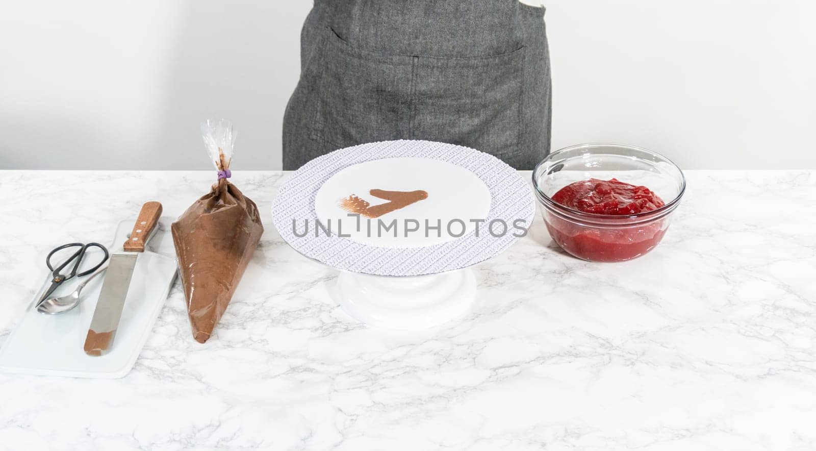 Covering chocolate cake with a crumb layer of chocolate buttercream frosting.