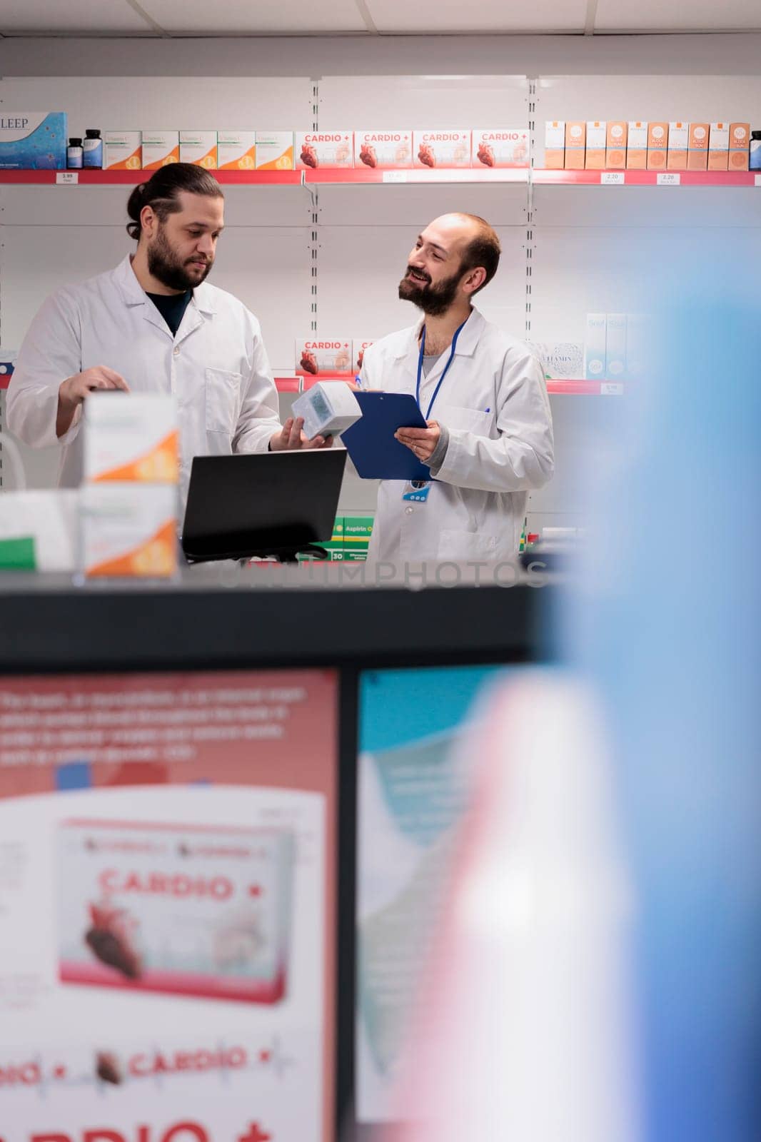 Drugstore colleagues standing at counter desk doing medication and pharmaceutical products inventory in pharmacy. Employees is trained to recognize and address any potential drug interactions