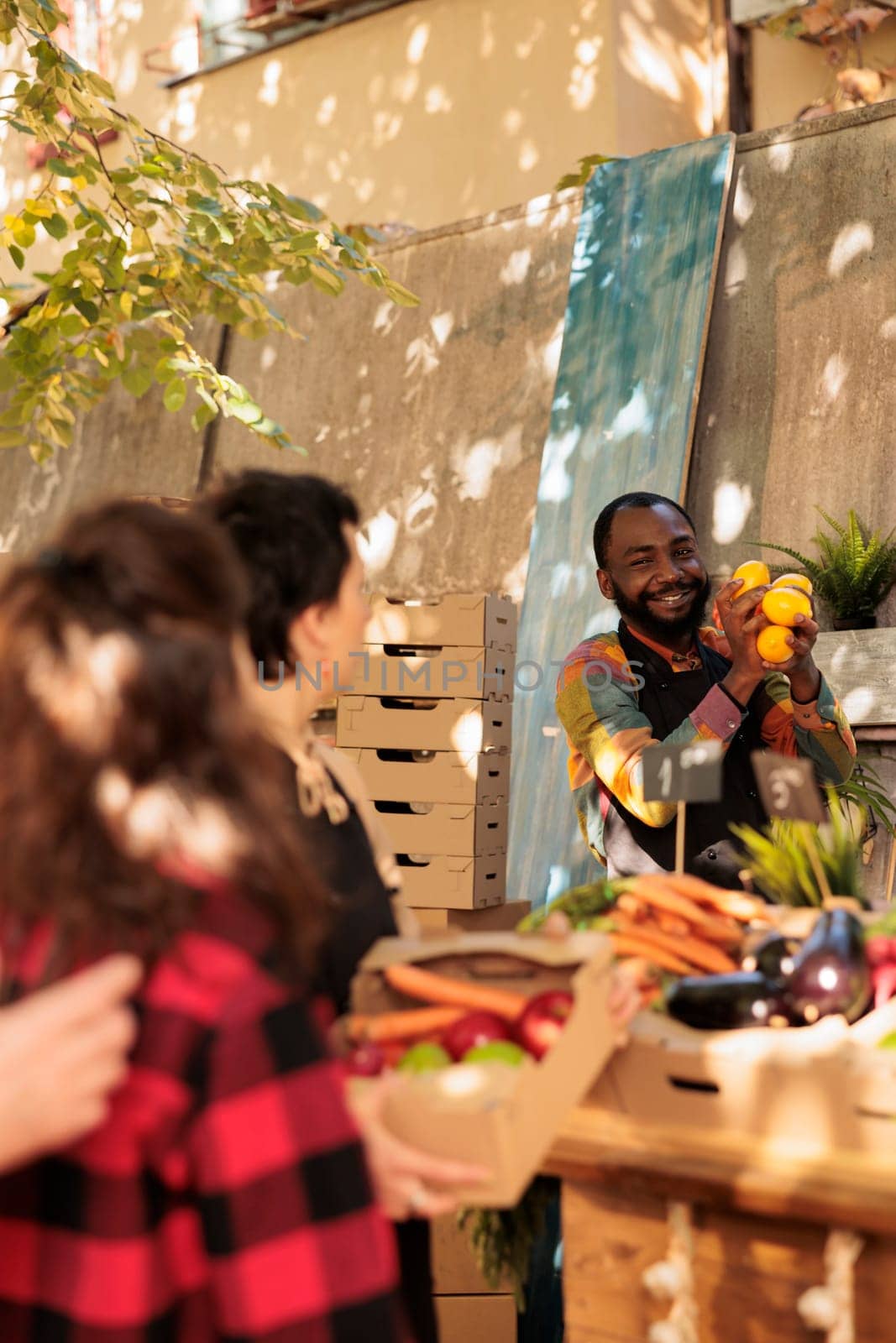 Happy African guy enjoying working day at farmers market by DCStudio