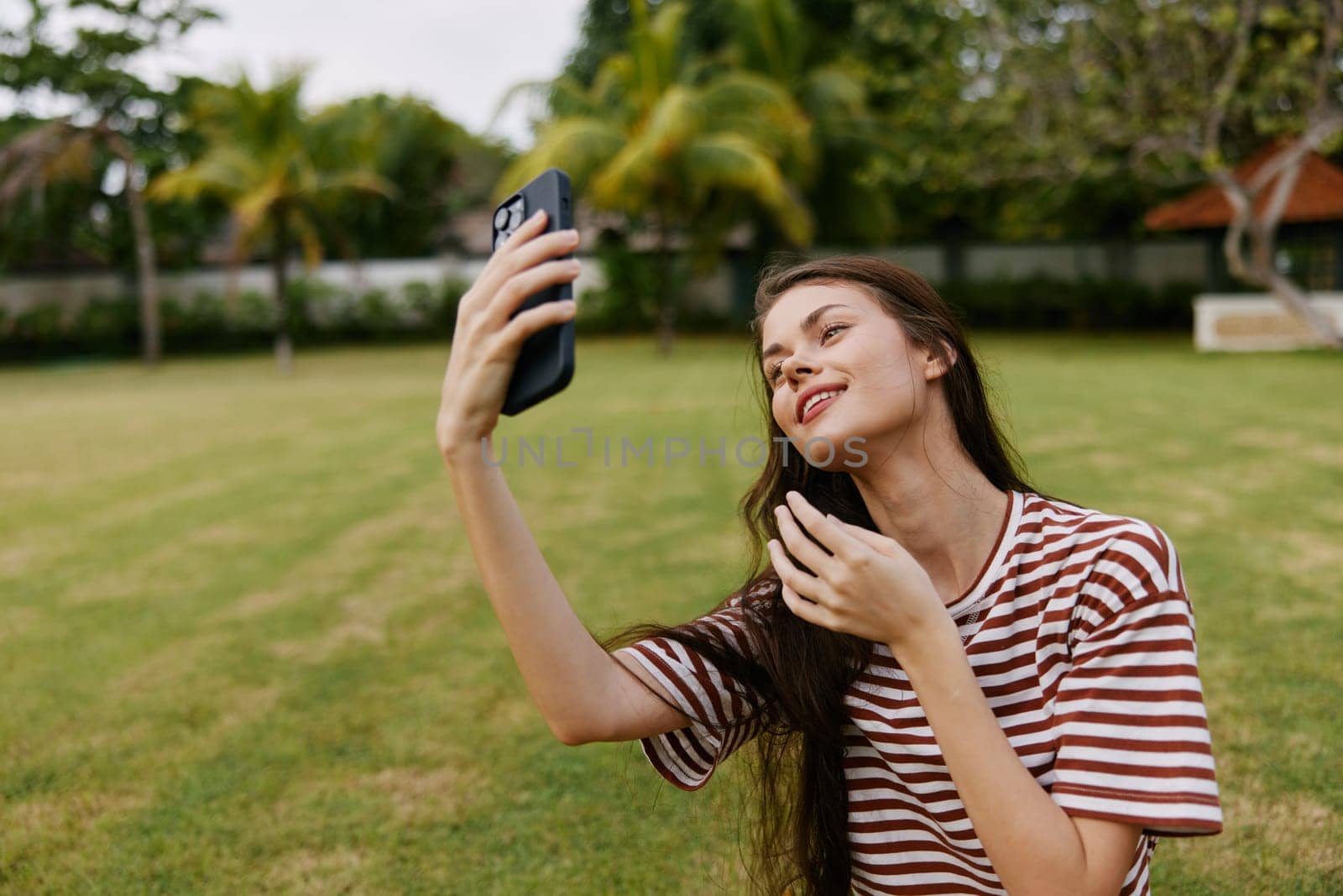 woman outside smiling palm person phone grass green tree park smart blogger nature working seasonal talk caucasian young spring talking happy lifestyle