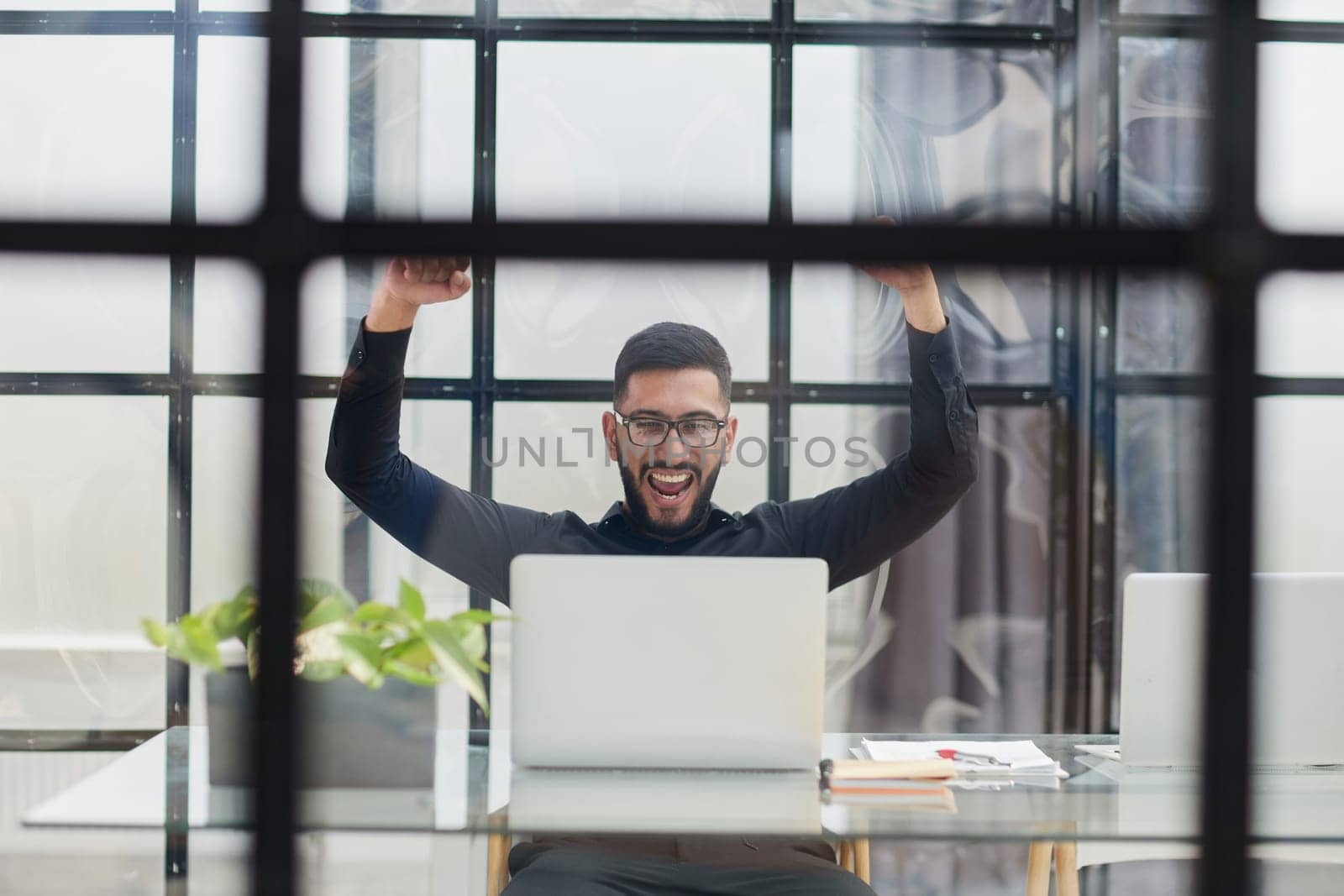 Business man sitting at his desk in the office with a laptop