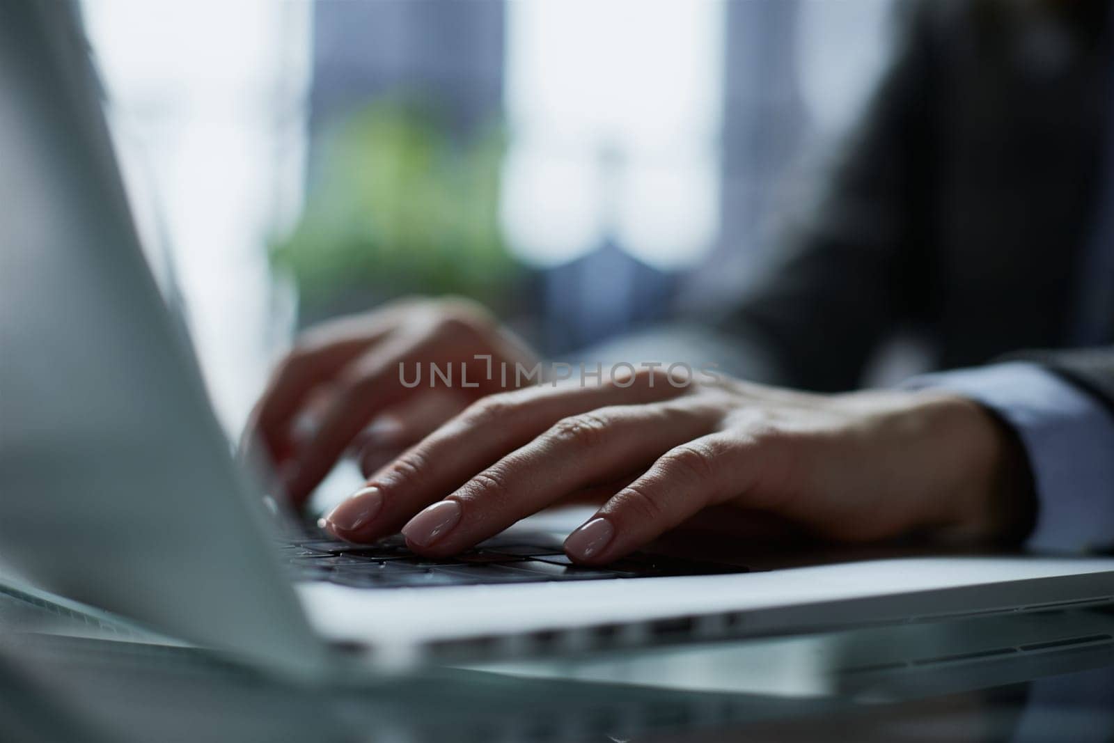 man's hands typing on laptop keyboard in interior