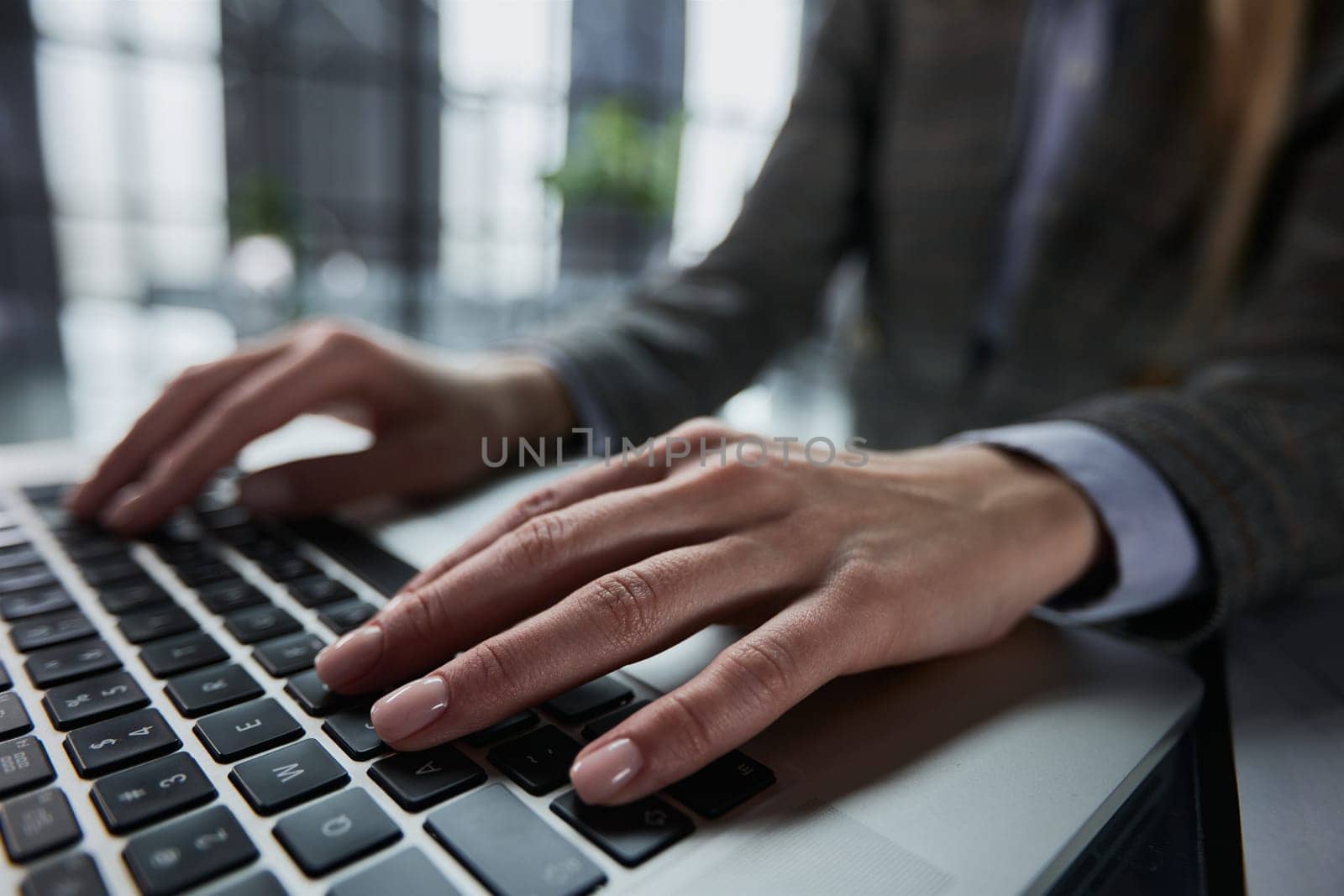 man's hands typing on laptop keyboard in interior