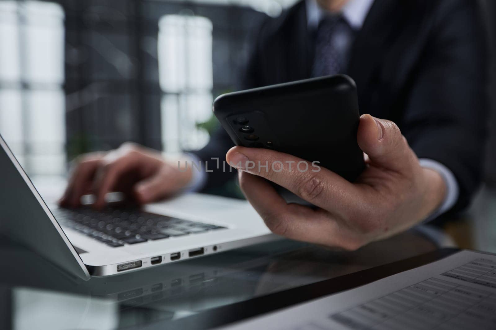 Side view shot of a man's hands using smart phone in interior,