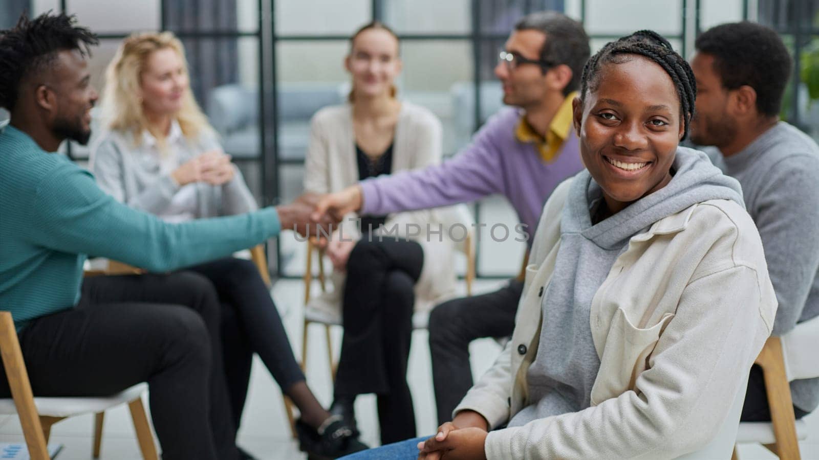 Successful African American manager sitting in front of her colleagues