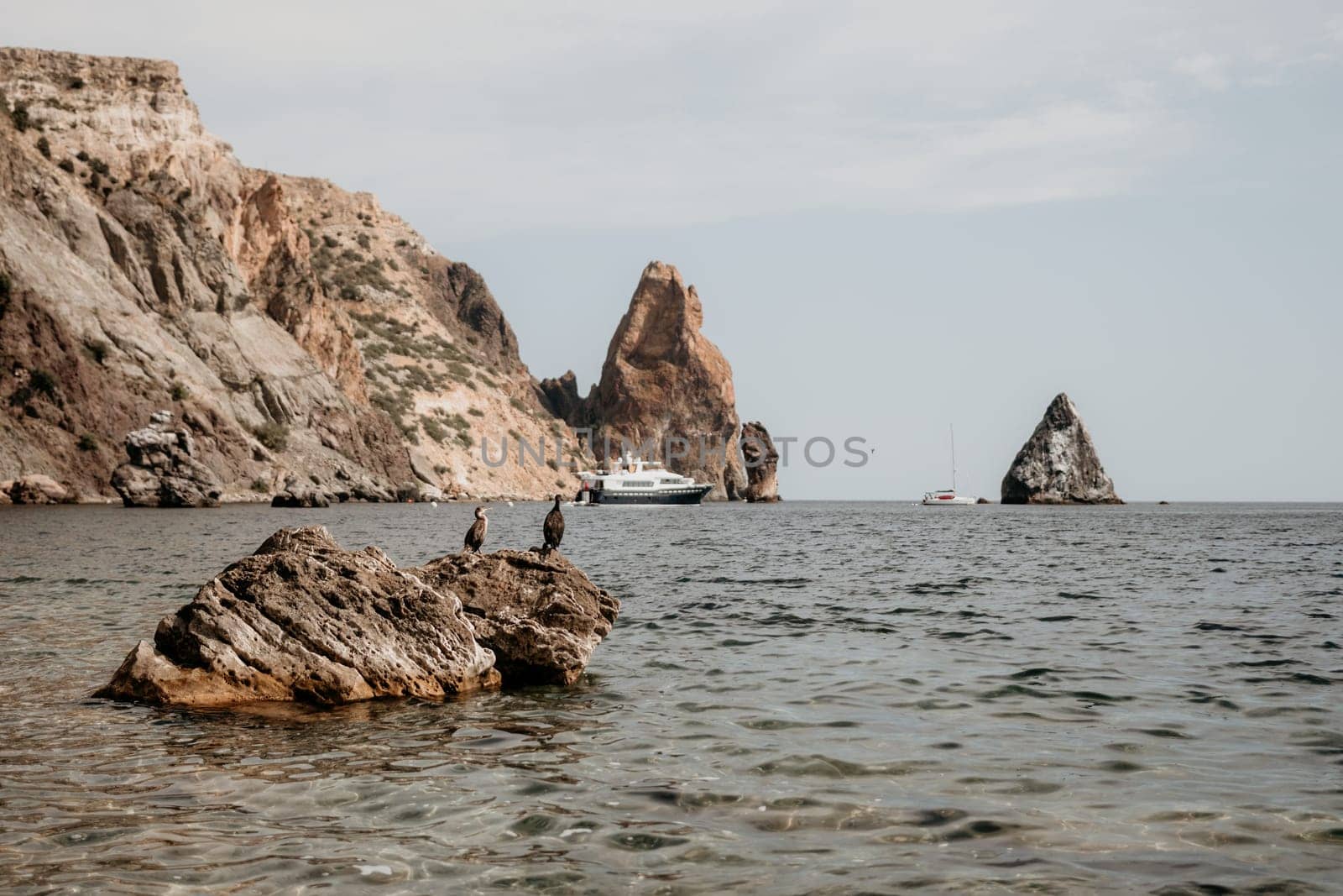 Remote beach, calm sea with volcanic rocky shores, with small waves on the water surface. The summer ocean beach, a holiday, vacation, and travel concept with a focus on natural scenery. Nobody by panophotograph