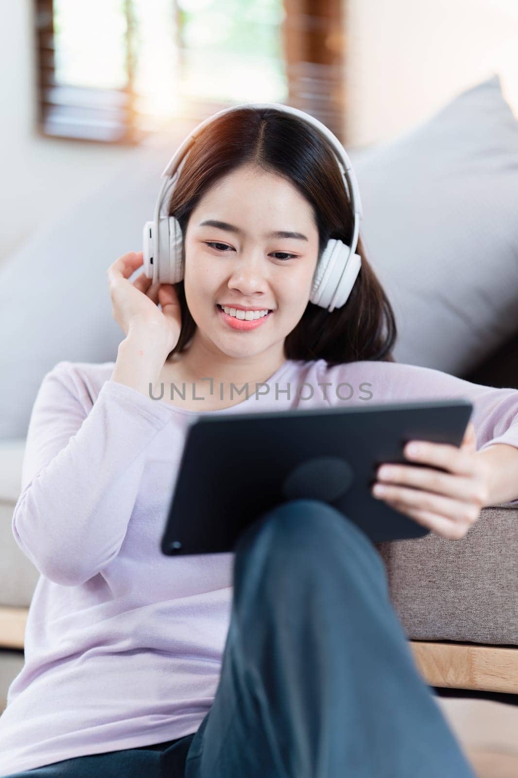 Attractive Asian woman resting comfortable living room and using digital tablet, Relax, Sofa, Lifestyle.