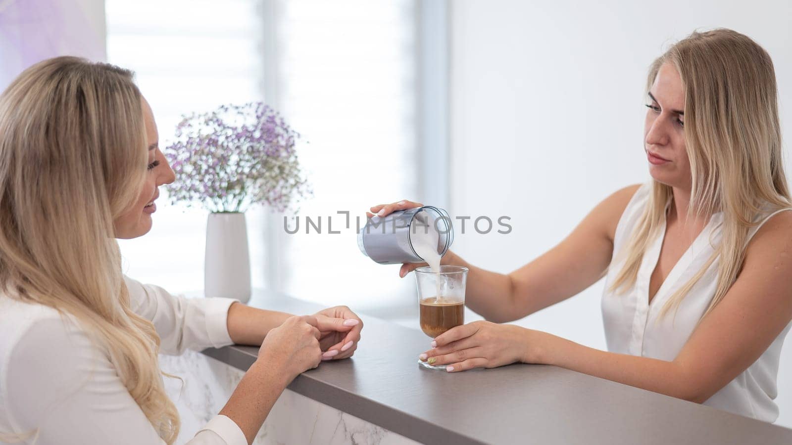 Receptionist in a beauty salon prepares coffee for a client