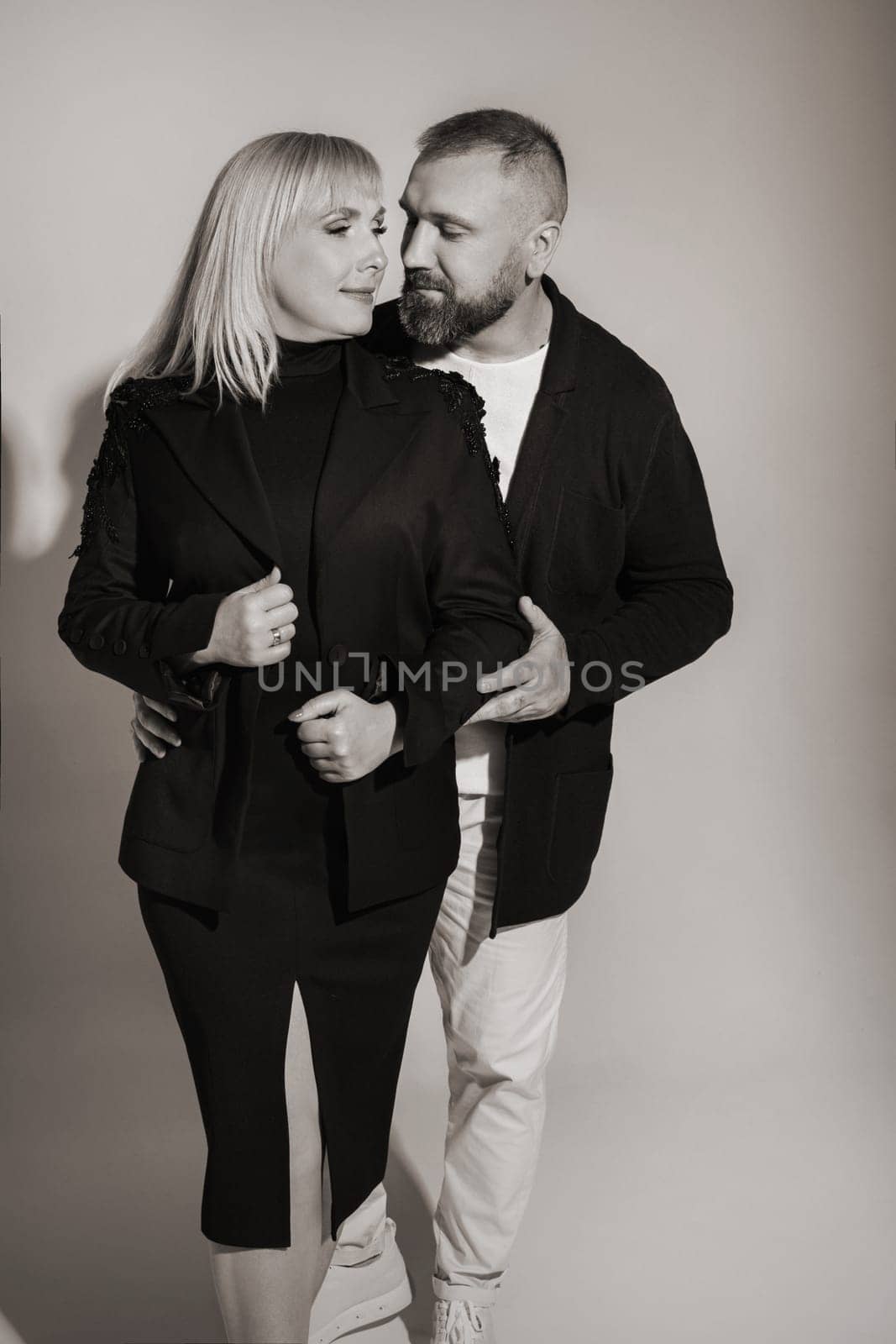 A man and a woman in strict clothes pose against the background in the studio by Lobachad