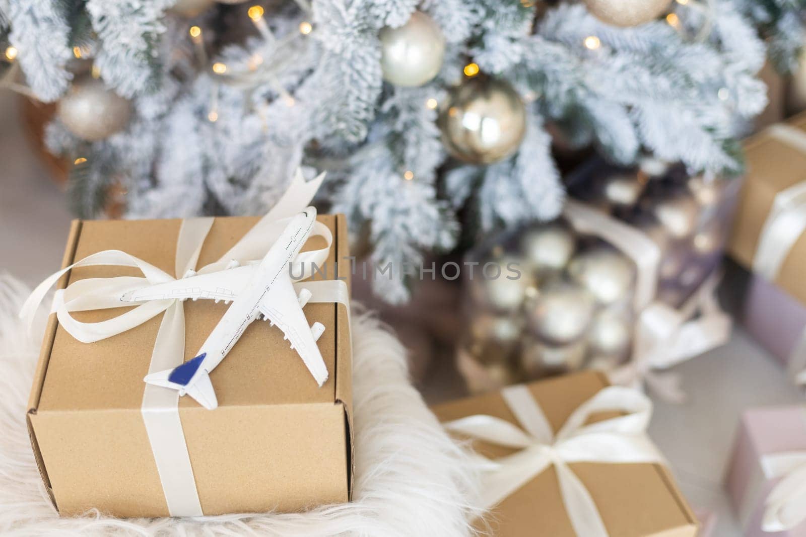 Beautiful Christmas gift boxes on floor near fir tree in room