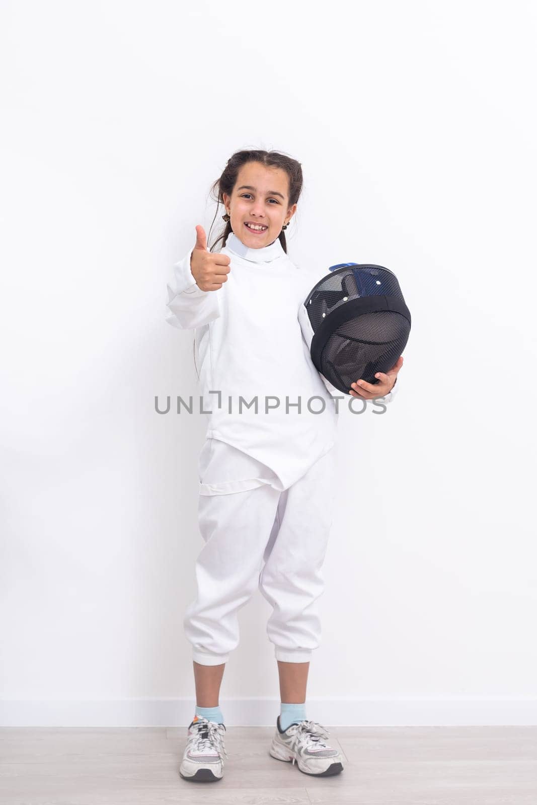 Little girl fencer with epee and mask.