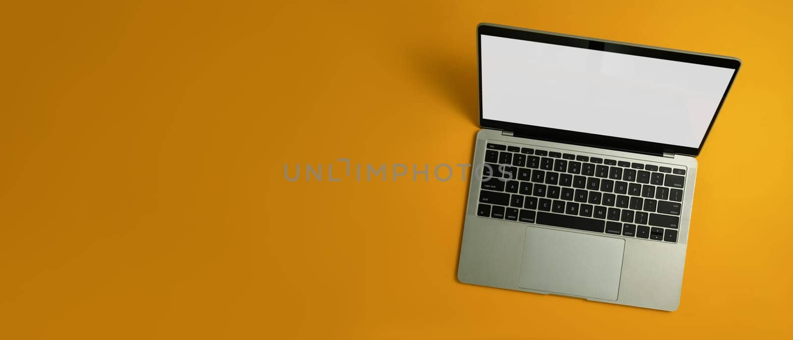 Laptop computer with white empty screen on yellow background with copy space for your advertise text.