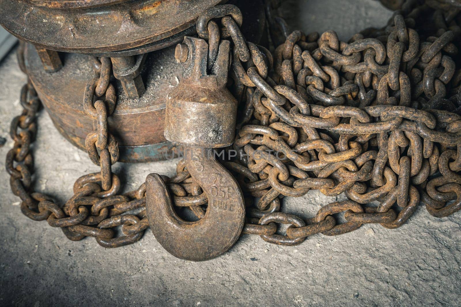 an old iron chain hoist with chain. a large hook for lifting loads by audiznam2609