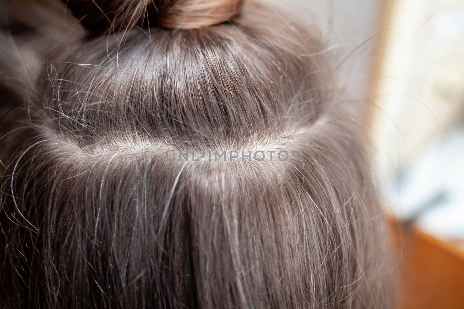 Hair ribbons for extensions on a woman's head at home. by AnatoliiFoto